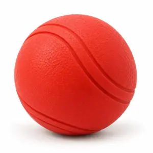 Roter Hundeball aus Vollgummi mit geschwungener Rille auf weißem Hintergrund